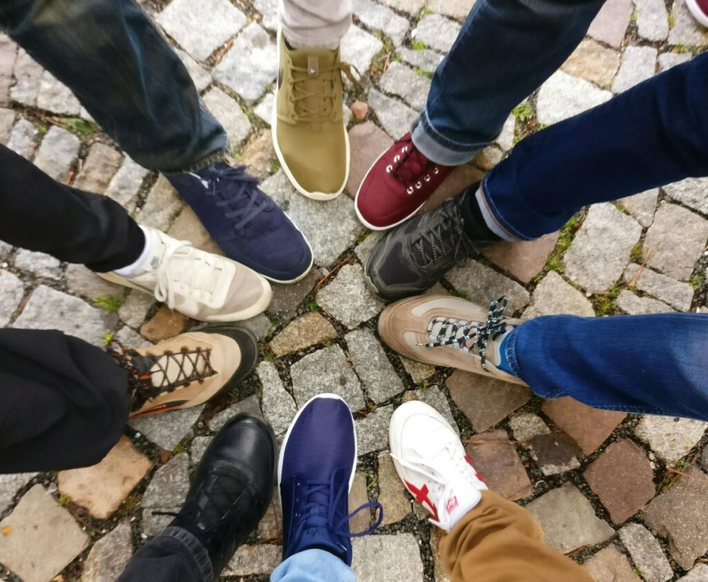 Füße mit unterschiedlichen Schuhen in der Mitte.